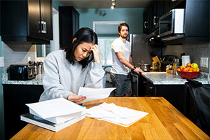 A couple suffering from financial hardship are in their home reviewing bills.